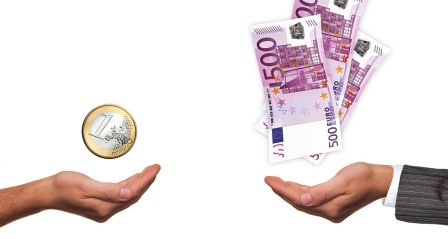 2 Hände, eine wirft einen Euro hoch, die andere 500 Euro-Scheine