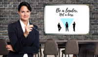 Frau vor einer Tafel mit Aufschrift Be a leader not a boss