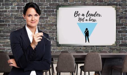 Frau vor einer Tafel auf der be al leader not a boss steht